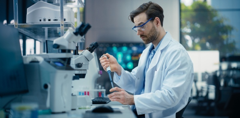 A man working in a lab wearing safety glasses.