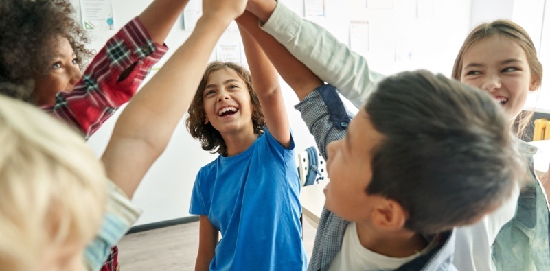 A group of children at school high-fiving