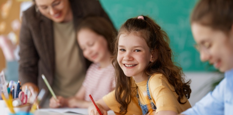 A young girl smiling in the classroom