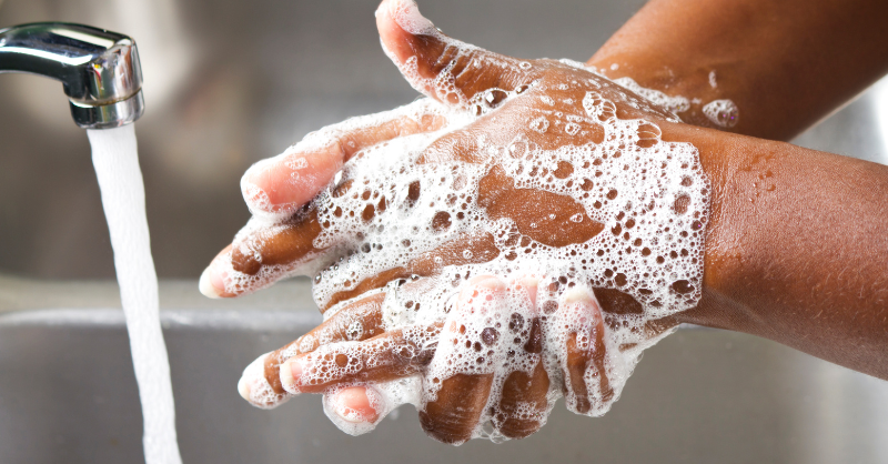 A close-up of a person washing their hands with soap and water.